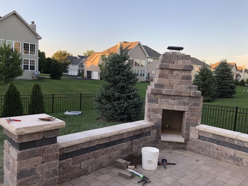 Paver patio with built-in seating wall and fire pit in Harvard IL