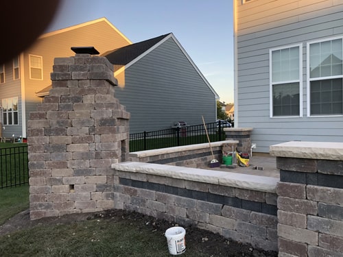 New backyard patio installation using stone pavers and decorative edging