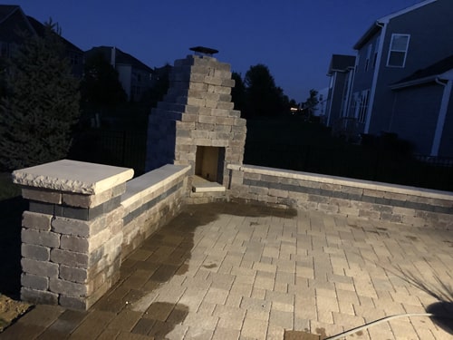 Elegant outdoor patio with pavers, landscaping, and lighting by Plant Garden Landscaping