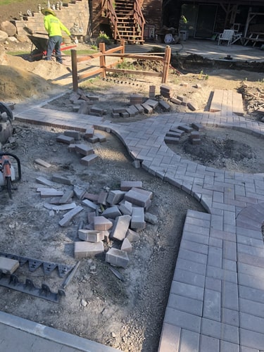 Curved brick walkway leading to a front entrance with surrounding landscaping