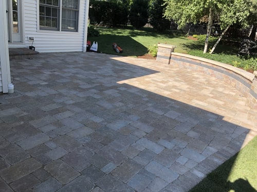 Backyard brick patio with outdoor furniture and landscaped edges